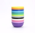 A stack of REPLAY Re-Play Large Bowls, made from BPA-free recycled plastic, arranged neatly on a white background. The bowls come in a variety of colors including yellow, blue, green, purple, pink, and black, creating a bright and vibrant composition.