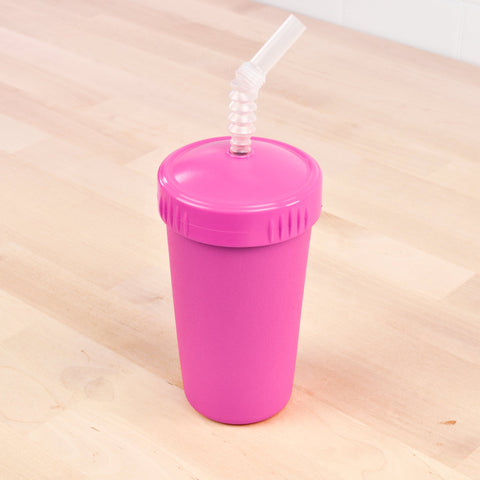 A Re-Play Straw Cup by REPLAY, featuring a pink plastic tumbler with a matching pink screw-on lid and a transparent curly straw, placed on a light wooden surface. This sustainable cup is proudly Made in the USA and perfect for those who love eco-friendly options like recycled straw cups.