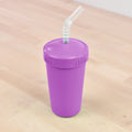 A sustainable purple REPLAY Re-Play Straw Cup with a matching lid sits on a light wooden surface. The lid features a built-in hole through which a flexible, translucent straw extends upwards. Made in the USA, this eco-friendly and stylish recycled straw cup is both practical and environmentally conscious.