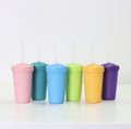 Six REPLAY Re-Play Straw Cups with matching lids and translucent straws are arranged in a row on a white surface. The cups come in light pink, teal, light blue, lime green, yellow, and purple. Made in the USA, they sit against a plain white wall.