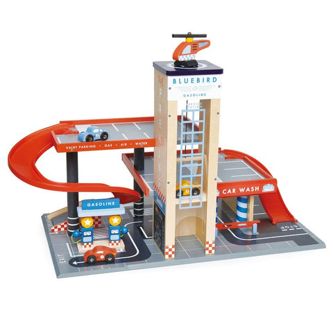 The Tender Leaf Blue Bird Service Station by Tender Leaf is a vibrant toy car garage playset, featuring a striking red spiral ramp, a helicopter perched on top, multiple levels, and dedicated sections for gasoline, car wash, and parking. Complete with wooden cars and accessories spread throughout the set, it sparks imaginative play for children.