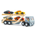 The Tender Leaf Car Transporter by Tender Leaf is a wooden toy with a painted blue cab and a detachable trailer featuring two levels, each carrying two colorful super cars. The trailer includes moving ramps, and the truck's cab showcases checkered patterns with two characters visible in the windows.